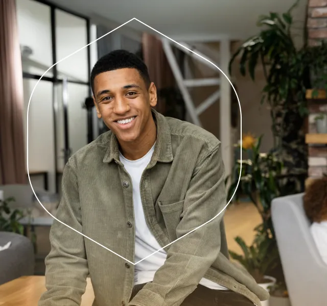 A person smiling in a bright office, representing care that fits real people.